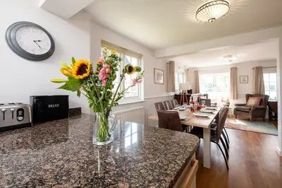 a vase of flowers on a counter in a kitchen at 5 The Haven in Thorpeness