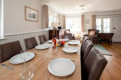 a dining room with a table with glasses and chairs at 5 The Haven in Thorpeness