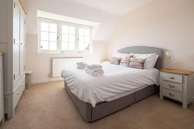 a bedroom with a large bed with white sheets and pillows at 5 The Haven in Thorpeness