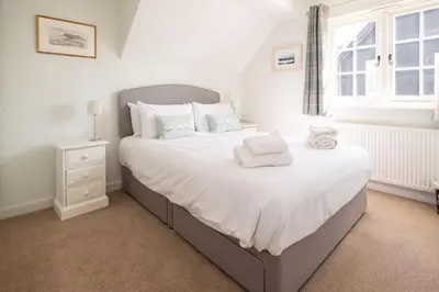 a bedroom with a large white bed with towels on it at 5 The Haven in Thorpeness