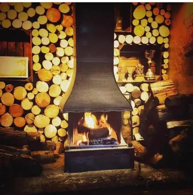 a fireplace with a fire in front of it at The British Queen, Meldreth in Meldreth