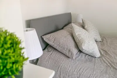 a bed with four pillows on it with a lamp at Hillcrest Lodge in Stevenage