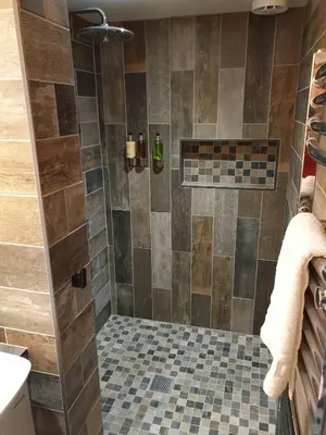 a bathroom with a shower with a tiled floor at CopperBeech Bed and Breakfast in Yoxford