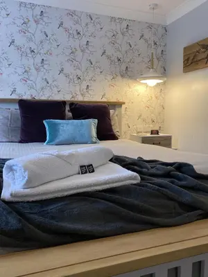a bedroom with a large bed with blue pillows at CopperBeech Bed and Breakfast in Yoxford