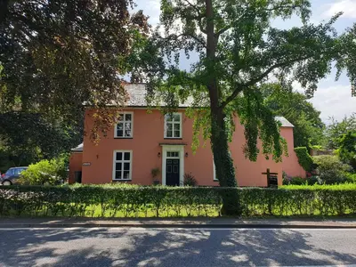 a pink house with a tree in front of it at CopperBeech Bed and Breakfast in Yoxford