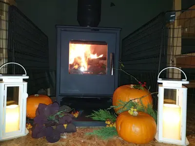 a fireplace with pumpkins and candles in front of it at Wingfield Escapes in Diss