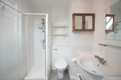 a white bathroom with a toilet and a sink at Colchester Town Duplex Apartment in Colchester