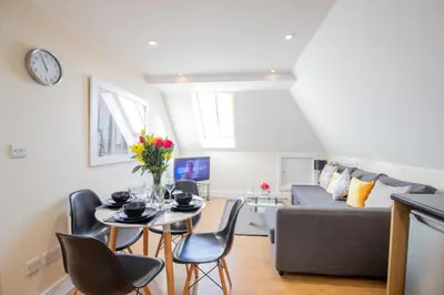 a living room with a table and chairs and a couch at Velvet 2-bedroom apartment, Clockhouse, Hoddesdon in Hoddesdon