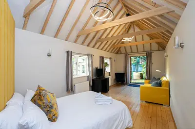 a bedroom with a white bed and a yellow couch at Pages Hotel and Guesthouse in Harlow