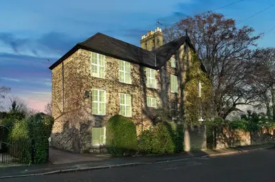 an old brick house with ivy on a street at Pages Hotel and Guesthouse in Harlow