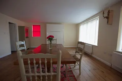 a dining room with a wooden table and chairs at Spacious Apartment with Roof Terrace, near The Waterfront, Ipswich in Ipswich
