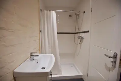 a white bathroom with a shower and a sink at Spacious Apartment with Roof Terrace, near The Waterfront, Ipswich in Ipswich