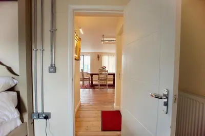 a hallway leading to a room with a table at Spacious Apartment with Roof Terrace, near The Waterfront, Ipswich in Ipswich