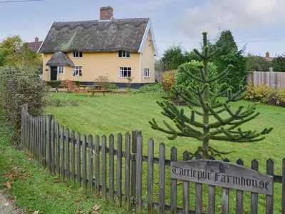 a fence with a sign in front of a house at Tattlepot Farmhouse in Tivetshall Saint Margaret