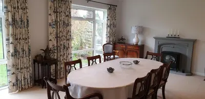 a dining room with a table and a fireplace at Cobblestones in Benington