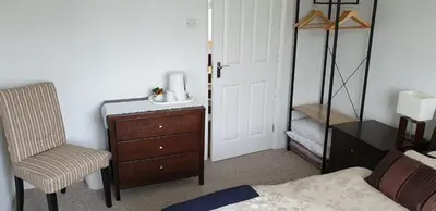 a bedroom with a bed and a dresser and a chair at Cobblestones in Benington