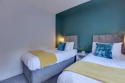 two beds in a room with blue walls at George Suite - Central Location - Free Allocated Parking in Chelmsford