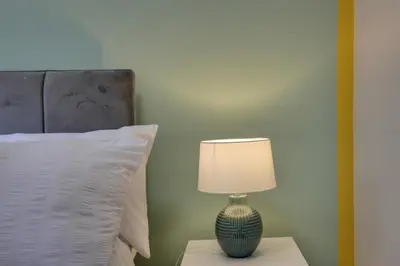 a lamp sitting on a table next to a bed at George Suite - Central Location - Free Allocated Parking in Chelmsford