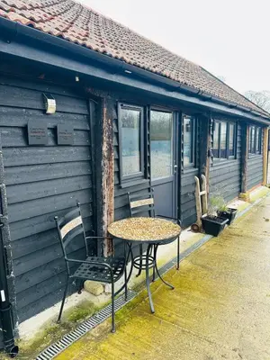 a table and chair in front of a cabin at The Stables & Silos in Braintree