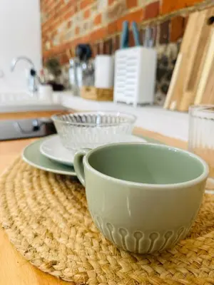 a white cup sitting on top of a table at The Stables & Silos in Braintree