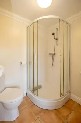 a bathroom with a shower and a toilet at 2 Hazelwood - 2 bedroom house near Aldeburgh & Snape Maltings - Aldeburgh Coastal Cottages in Aldringham