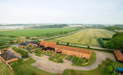 an aerial view of a building in a field at 2 Hazelwood - 2 bedroom house near Aldeburgh & Snape Maltings - Aldeburgh Coastal Cottages in Aldringham