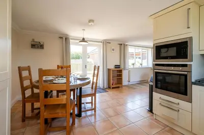 a kitchen and dining room with a table and chairs at 2 Hazelwood - 2 bedroom house near Aldeburgh & Snape Maltings - Aldeburgh Coastal Cottages in Aldringham