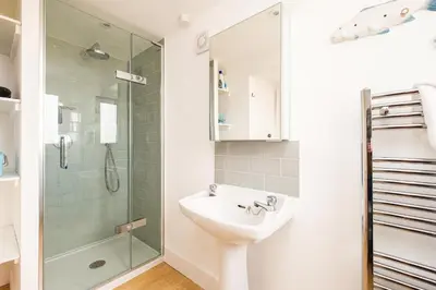a bathroom with a sink and a shower at Shore Cote, Thorpeness in Thorpeness