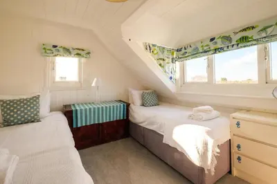 a small bedroom with two beds and a window at Shore Cote, Thorpeness in Thorpeness