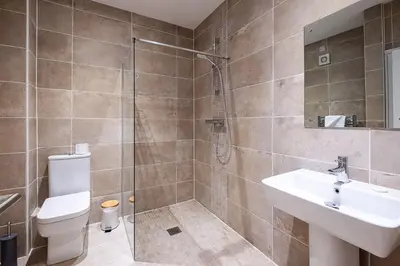a bathroom with a shower and a sink and a toilet at Three Tuns Apartments - Ash in Pettistree