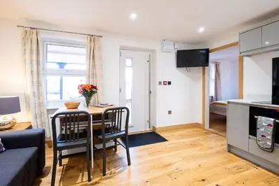 a living room with a table and a couch at Three Tuns Apartments - Sycamore in Pettistree