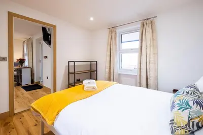 a bedroom with a white bed and a window at Three Tuns Apartments - Sycamore in Pettistree
