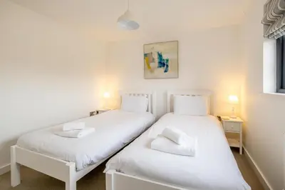 two twin beds in a room with white walls at 5 Oakes Court in Thorpeness