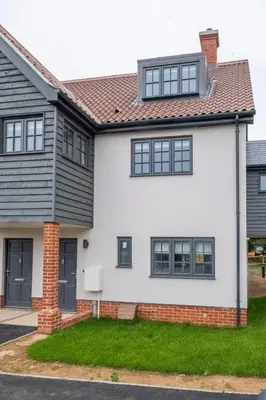 a white house with black windows at 5 Oakes Court in Thorpeness