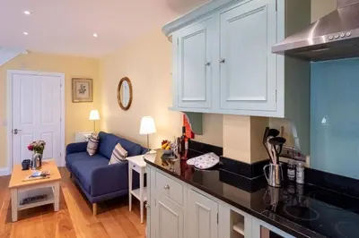 a kitchen and a living room with a blue couch at 4 Wards Place in Aldeburgh