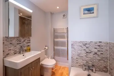 a bathroom with a sink and a toilet and a mirror at 4 Wards Place in Aldeburgh