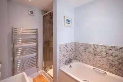 a bathroom with a bath tub and a shower at 4 Wards Place in Aldeburgh