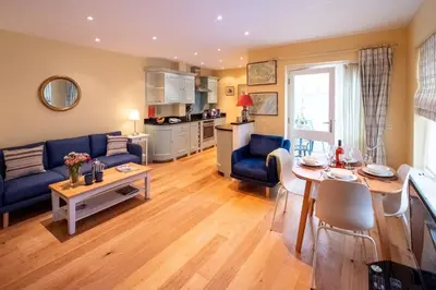 a living room with a blue couch and a table at 4 Wards Place in Aldeburgh