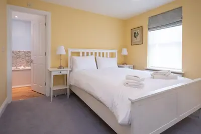 a bedroom with a large white bed and a window at 4 Wards Place in Aldeburgh