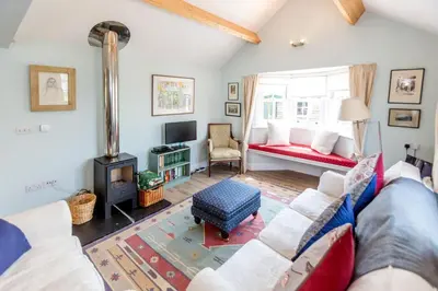 a living room with a couch and a fireplace at The Pink House, Thorpeness in Thorpeness