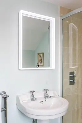 a white bathroom with a sink and a mirror at The Pink House, Thorpeness in Thorpeness