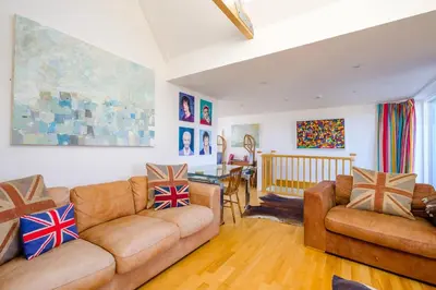 a living room with two couches and a dining room at Gunfleet, Aldeburgh - A Large Seafront House with Stunning Sea Views from all the floors, Sleeps 14 - Aldeburgh Coastal Cottages in Aldeburgh
