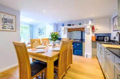 a kitchen with a wooden dining table and chairs at Gunfleet, Aldeburgh - A Large Seafront House with Stunning Sea Views from all the floors, Sleeps 14 - Aldeburgh Coastal Cottages in Aldeburgh