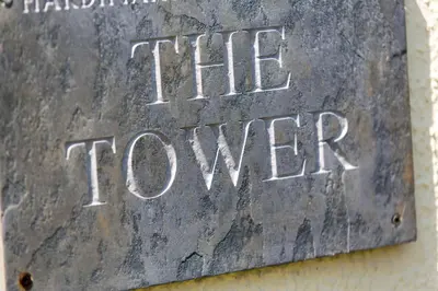 a metal sign that says the tower with writing on it at The Tower in Thorpeness