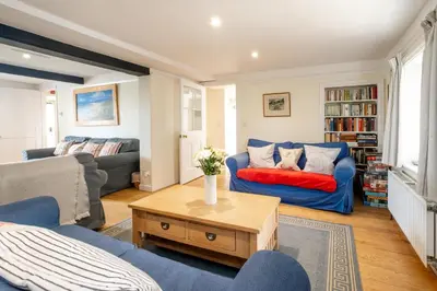 a living room with a blue couch and a table at Sea View, Thorpeness in Thorpeness