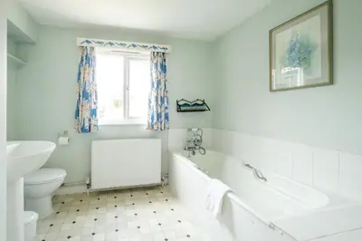 a bathroom with a tub and a toilet and a sink at Sea View, Thorpeness in Thorpeness