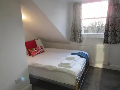 a small bed in a room with a window at The Tas Suites - Tas Accommodations in Cambridge