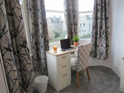 a desk with a laptop on it in front of a window at The Tas Suites - Tas Accommodations in Cambridge