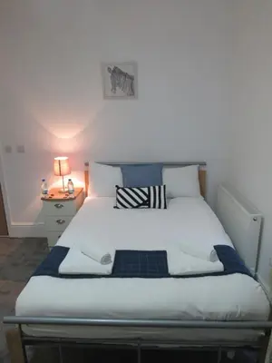 a bed in a small room with a nightstand and a bed sidx sidx sidx at The Tas Suites - Tas Accommodations in Cambridge