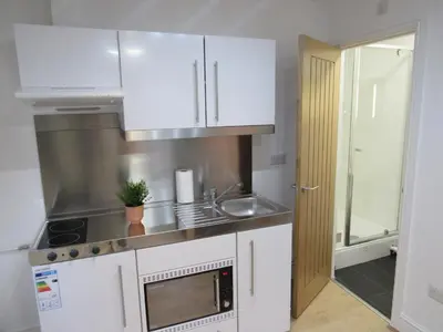 a kitchen with white cabinets and a sink at The Tas Suites - Tas Accommodations in Cambridge